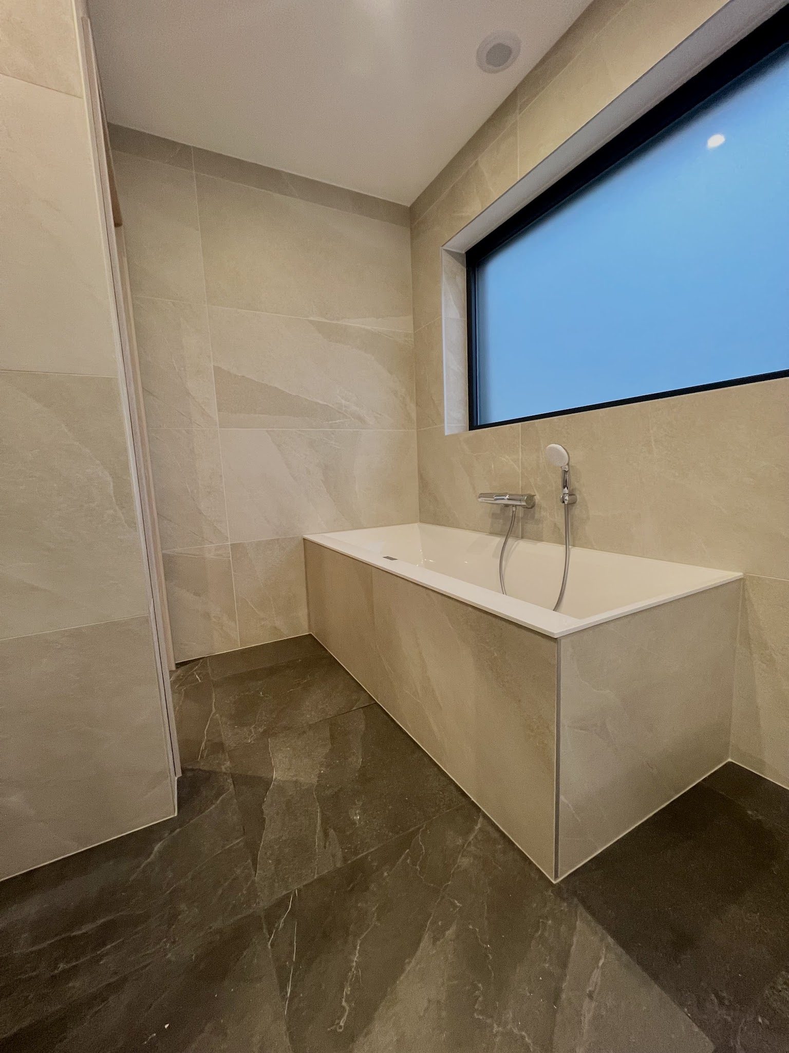 Baignoire habillée de carrelage effet marbre grand format