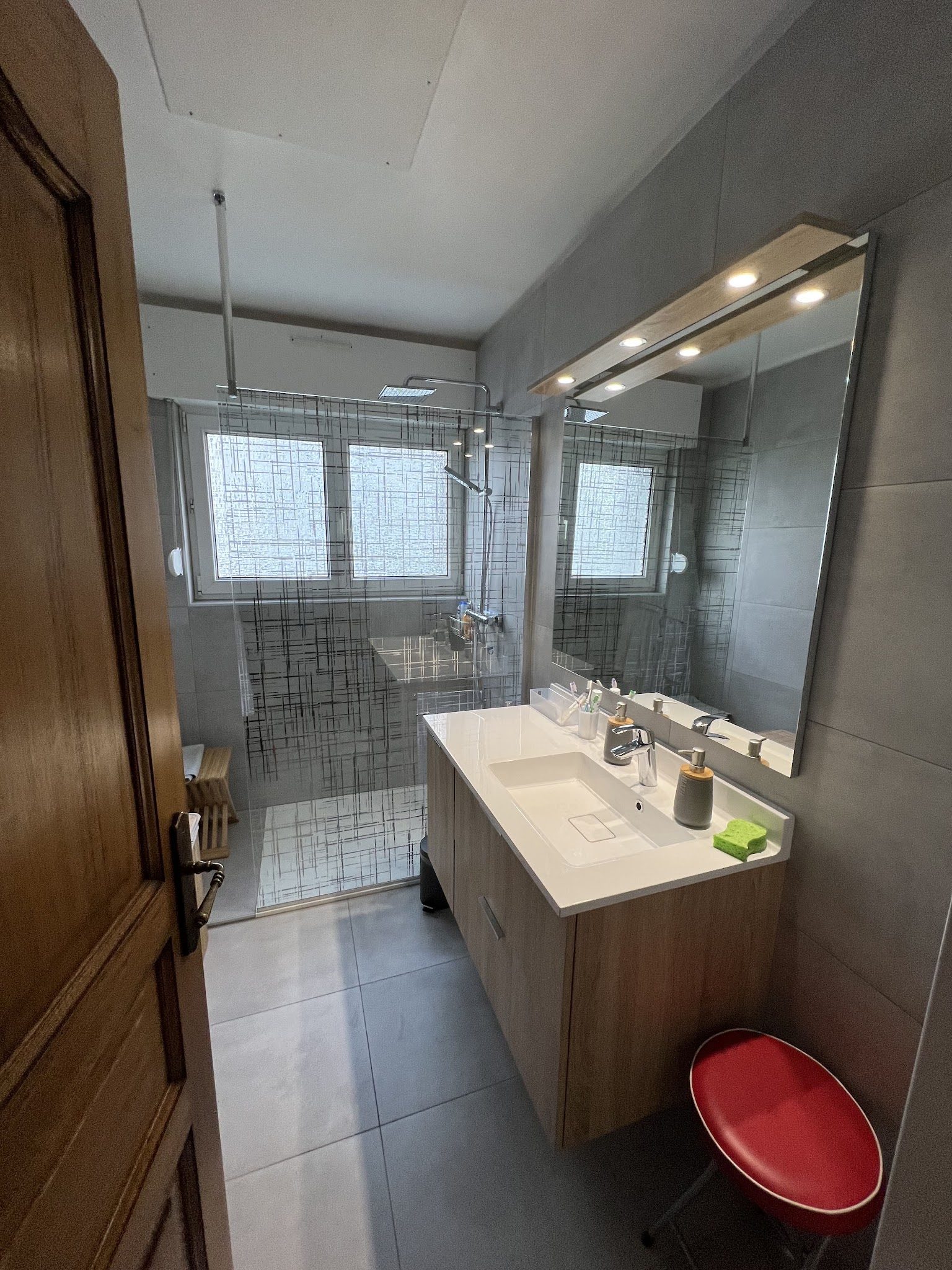 Salle de bains avec douche vitrée et meuble bois